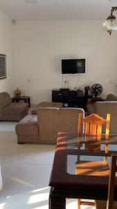 ein Wohnzimmer mit einem Sofa und einem Tisch in der Unterkunft Chácara Recanto Wonne in Trindade