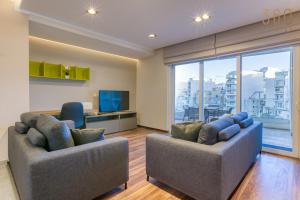 een woonkamer met 2 stoelen en een groot raam bij Luxury 3BR home in St Julians with private terrace by 360 Estates in Taʼ Ċikkun