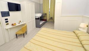 una camera d'albergo con letto, tavolo e scrivania di Hotel Ariston a Livorno