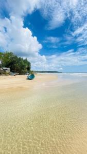 a beach with a blue boat sitting on the sand at Simplex Sea Place in Tangalle