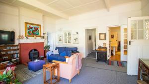 a living room with a blue couch and a fireplace at Uitkyk in Fish hoek