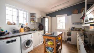 a kitchen with a washer and dryer in it at Uitkyk in Fish hoek