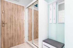 a pivot door in a hallway with wood paneling at Apartament z Garażem! Kołobrzeg -Rybacka przy Ścieżce Rowerowej in Kołobrzeg