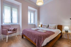 - une chambre avec un lit, une chaise et des fenêtres dans l'établissement Apartamento Moderno com Terraço, à Lisbonne