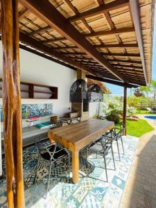 Un patio al aire libre con una mesa y sillas de madera. en Casa Saíra, a 300 metros da praia do Patacho, Porto de Pedras-AL, en Porto de Pedras