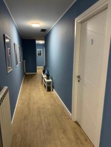 un corridoio con pareti blu e una porta bianca di Casa flowers a Ciampino