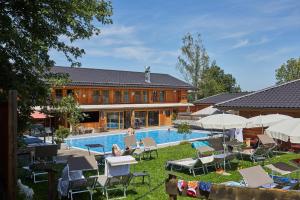 ein Resort mit Pool und Liegestühlen und einem Gebäude in der Unterkunft Bayern Chalets bei Salzburg und Berchtesgaden mit Whirlpool und Sauna in Ainring