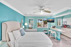 a blue bedroom with a bed and a kitchen at Walkabout 6 Suite on Hollywood Beach with Ocean Views in Hollywood