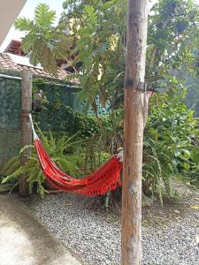 a red hammock in a garden next to a tree at Posada J in Baños