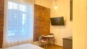 a kitchen with a table and a window with a tv at Filosoofi 1 Studio Apartments in Tartu