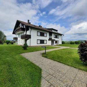 a large white house with a grass yard at Ferienwohnung Seeglück 