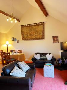 a living room with two leather couches and a table at Ballyknocken Milking Parlour Self Catering Apartment in Coolnakilly