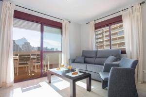 un soggiorno con divano e tavolo di Apartamento Coral Beach - PlusHolidays a Calpe