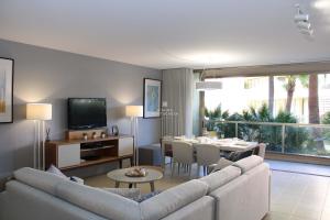 een woonkamer met een bank en een eetkamer bij Coco Design Apartment Salgados Beach - By Dalma Portuguesa in Galé