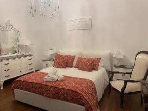 a bedroom with a bed and a chair and a mirror at Maison al Duomo in Messina