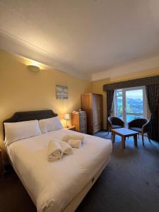 a bedroom with a large bed with towels on it at The Royal Lion Hotel in Lyme Regis