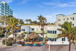 Blick auf das Hotel vom Strand mit Palmen in der Unterkunft Walkabout 3 King Suite on the Ocean in Hollywood Beach in Hollywood