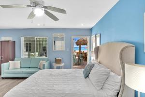 Walkabout 2 Oceanfront Suite on Hollywood Beach في هوليوود: غرفة نوم بجدران زرقاء وسرير واريكة