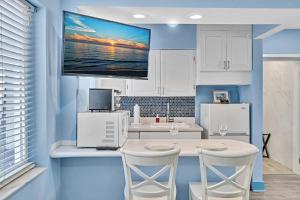a kitchen with a table with two chairs and a tv on the wall at Walkabout 2 Oceanfront Suite on Hollywood Beach in Hollywood