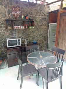 Posada J في بانوس: طاولة وكراسي في مطبخ مع ميكروويف