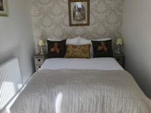 コンウィにあるDowntown Cottage Conwyのベッドルーム1室(白いベッド1台、ナイトスタンド2台付)