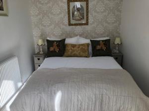 a bedroom with a white bed with two night stands at Downtown Cottage Conwy in Conwy