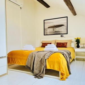 1 dormitorio con 1 cama con manta amarilla en Cozy Loft in a fashion district of Milan, en Milán
