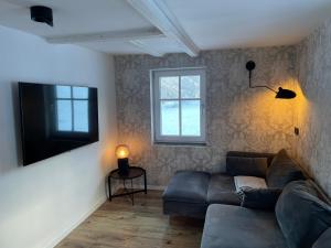 a living room with a couch and a television at Das schräge Häusl in Rangersdorf