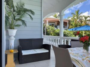 a patio with a table and chairs on a porch at Sun Caraibes in Orient Bay