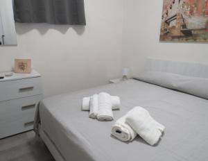 een wit bed met drie opgerolde handdoeken erop bij Casa Veneto in Mazara del Vallo