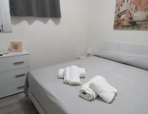 a white bed with three rolled towels on it at Casa Veneto in Mazara del Vallo