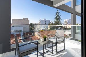 einen Balkon mit 2 Stühlen und einem Tisch in der Unterkunft Stars 1-Bedroom Apartment in Larnaca in Larnaka