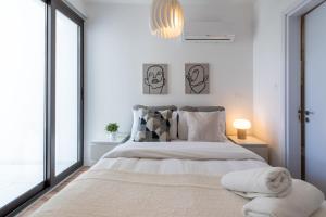 ein weißes Schlafzimmer mit einem großen Bett mit Kissen in der Unterkunft Stars 1-Bedroom Apartment in Larnaca in Larnaka