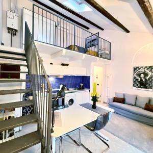cocina abierta y sala de estar con mesa blanca y escaleras en Cozy Loft in a fashion district of Milan, en Milán