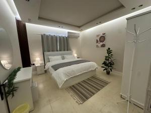 um quarto com uma grande cama branca e um tapete em شقة فاخرة غرفتين نوم ودخول ذاتي em Riyadh