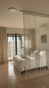 a bedroom with a bed with curtains and windows at Casa Valentina 3 in Perugia