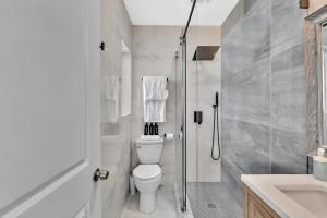 a white bathroom with a shower and a toilet at Walkabout 7 Historic Hotel on the beach Live music and bar in Hollywood
