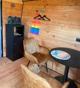 ein Esszimmer mit einem Tisch und Stühlen sowie einer Holzwand in der Unterkunft Hoogte Huisje Fantasie in Swalmen