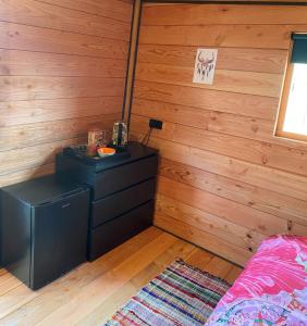 een slaapkamer met houten lambrisering en een bed in een kamer bij Hoogte Huisje Fantasie in Swalmen