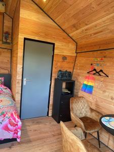 Zimmer mit einer Tür, einem Tisch und einem Stuhl in der Unterkunft Hoogte Huisje Fantasie in Swalmen