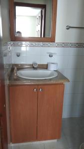 ein Bad mit einem Waschbecken und einem Spiegel in der Unterkunft San Juan Del Lago in Pereira