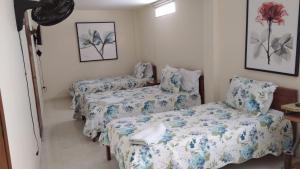 a room with two beds and a table at San Juan Del Lago in Pereira