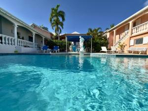 a swimming pool with a statue in front of a building at Sun Caraibes in Orient Bay