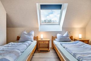 two beds in a room with a window at Ferienwohnung Dornhege in Borken
