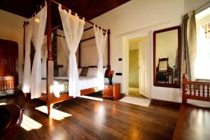a bedroom with a canopy bed and a mirror at Craigmore By Kodai Resort Hotel in Kodaikānāl