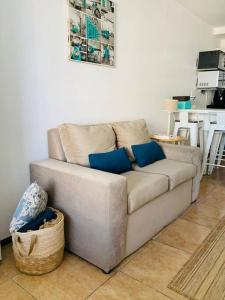 un sofá con almohadas azules en la sala de estar. en Apartamento hermoso cómodo en la mejor zona, en Montevideo