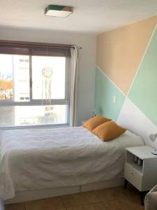 a bedroom with a bed and a large window at Apartamento hermoso cómodo en la mejor zona in Montevideo