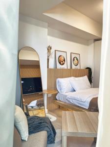 1 dormitorio con cama y espejo en Cozy Kkum - Korean Inspired Staycation at Azure North, en Lagundi