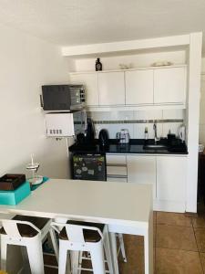 une cuisine avec une table blanche et des armoires blanches dans l'établissement Apartamento hermoso cómodo en la mejor zona, à Montevideo