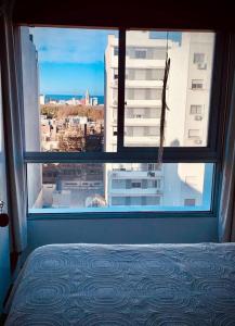 a bedroom window with a view of a city at Apartamento hermoso cómodo en la mejor zona in Montevideo